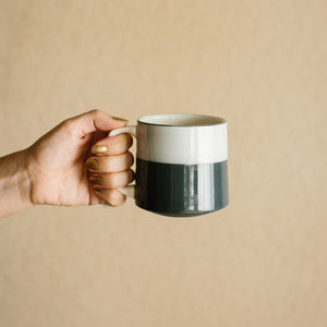 Hand holding one misty morning ceramic mug