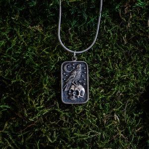 Silver skull and raven charm