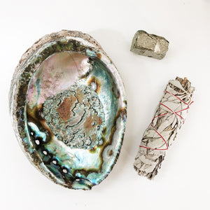 Pyrite chunk and sage stick next to a abalone shell