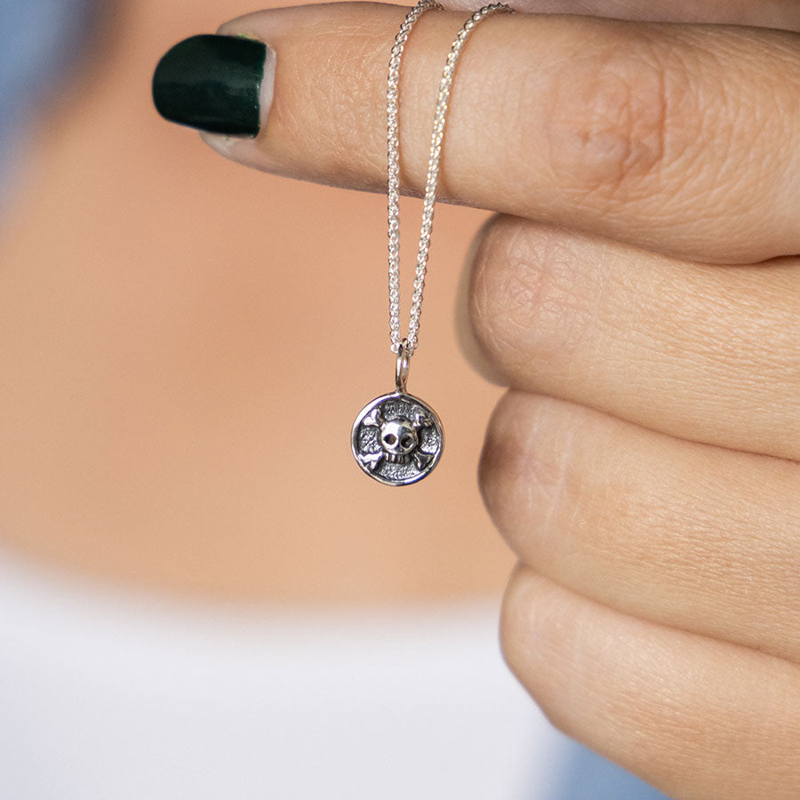 Silver skull and crossbones charm