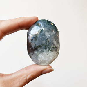 Hand holding a Moss Agate palm stone