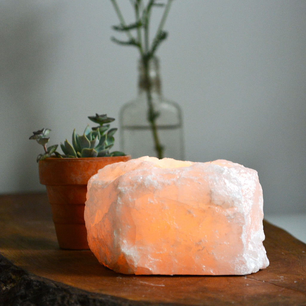 Lit candle inside a Rose Quartz candle holder