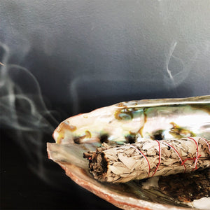 Burning Sage Smudge Stick in abalone shell