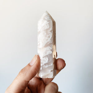 Hand holding a single White Agate Tower